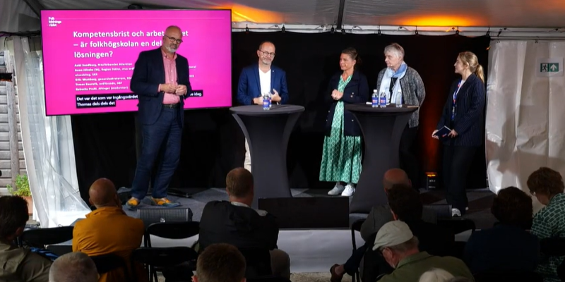 Fem pseroner står på en scen framför en publik.